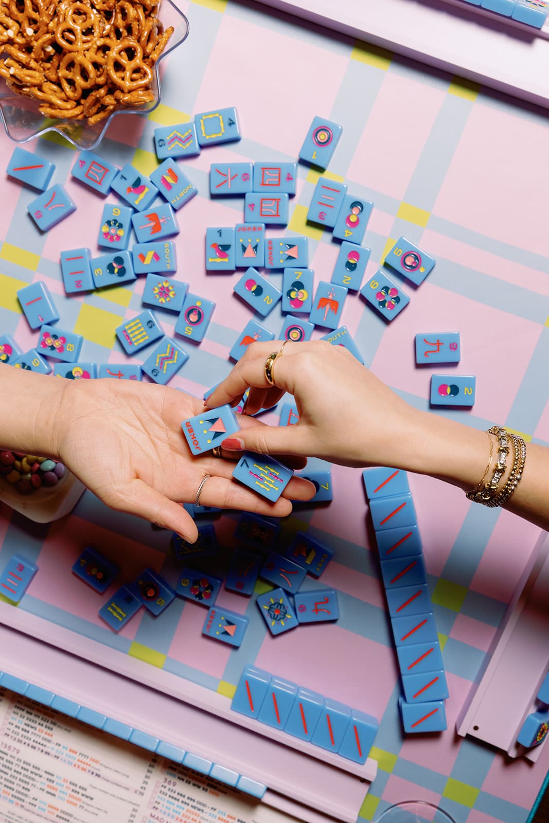 Two players exchanging a bright blue mahjong tile